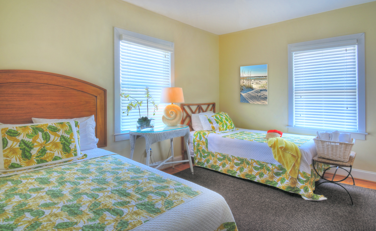 Bedroom at The Cottage with two beds and brightly colored bedding.
