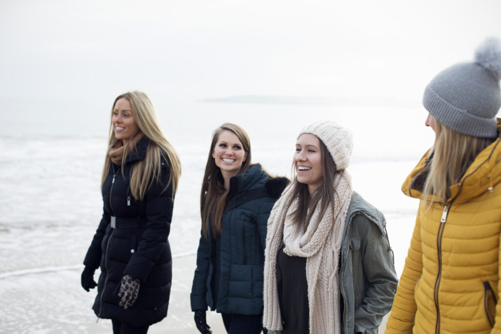 Friends walking along the beach in winter.